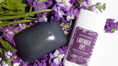 Schmidt's Lavender+Sage bar soap and Lavender Tips deodorant for sensitive skin on top of purple flowers and white background